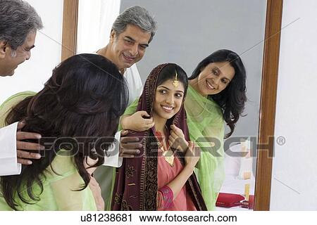 Stock Image - Parents dressing up their daughter . Fotosearch