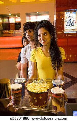 Stock Photograph - People at cinema lobby buying popcorn and soft drink . Fotosearch