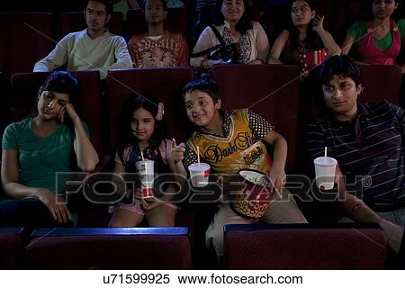 Stock Photography - People getting bored during a movie . Fotosearch