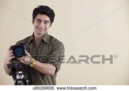 Photographer with camera on the tripod, smiling View Large Photo Image Stock Photography - Photographer with camera on the tripod, smiling . Fotosearch