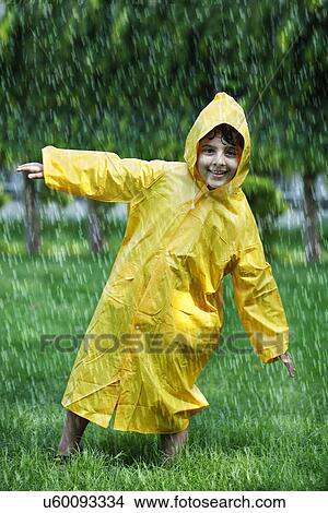 Picture - Playful boy wearing raincoat in park . Fotosearch