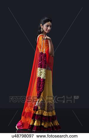 Portrait of a beautiful bride holding a garland View Large Photo Image Stock Photo - Portrait of a beautiful bride holding a garland. Fotosearch