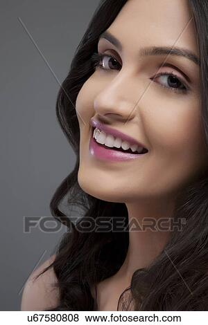 Stock Photo - Portrait of a beautiful female smiling over colored background . Fotosearch