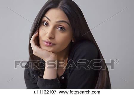Portrait of a bored young woman with hand on chin isolated over colored background View Large Photo Image Stock Photo - Portrait of a bored young woman with hand on chin isolated over colored background . Fotosearch