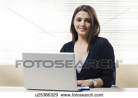 Stock Photo - Portrait of a businesswoman working on a laptop . Fotosearch