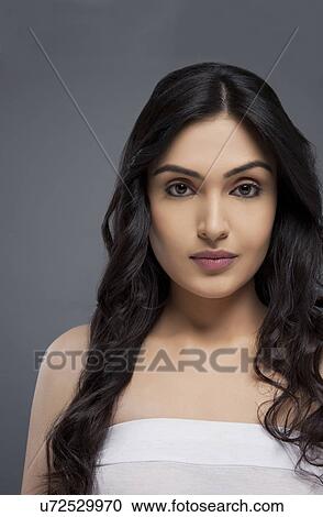 Portrait of a confident young female with long hair over colored background View Large Photo Image Stock Image - Portrait of a confident young female with long hair over colored background . Fotosearch