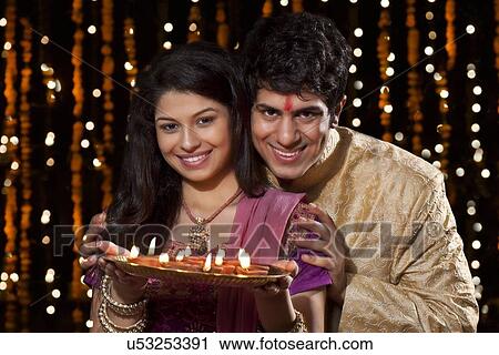 Portrait of a couple with a tray of diyas View Large Photo Image Stock Image - Portrait of a couple with a tray of diyas. Fotosearch