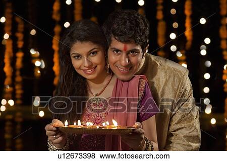 Stock Photo - Portrait of a couple with a tray of diyas. Fotosearch