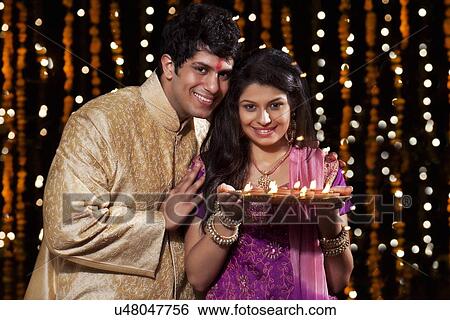 Stock Photograph - Portrait of a couple with a tray of diyas. Fotosearch