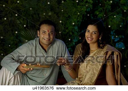 Stock Photograph - Portrait of a couple with diyas . Fotosearch