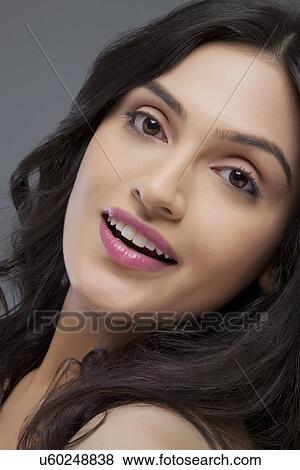 Stock Photo - Portrait of a cute young female smiling over colored background . Fotosearch