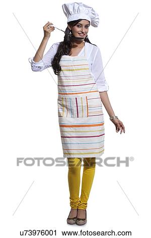 Stock Image - Portrait of a female chef tasting. Fotosearch