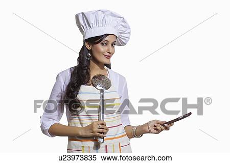 Stock Photography - Portrait of a female chef with cooking utensils. Fotosearch