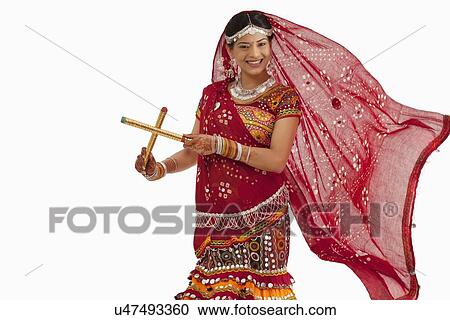 Stock Image - Portrait of a female dandiya dancer with sticks . Fotosearch
