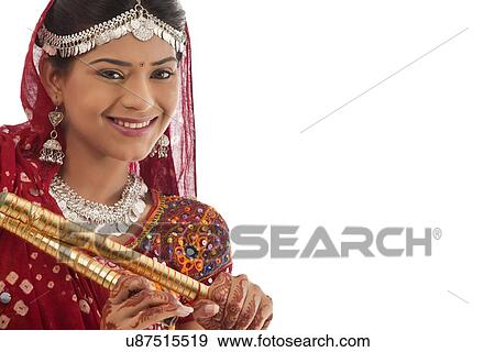 Stock Photo - Portrait of a female dandiya dancer with sticks . Fotosearch