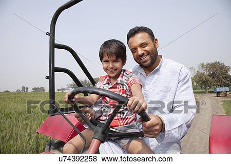 Portrait of a happy father and son driving tractor View Large Photo Image Stock Photo - Portrait of a happy father and son driving tractor . Fotosearch