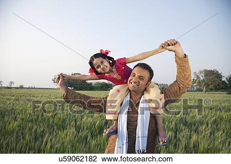 Portrait of a happy father carrying daughter on shoulders View Large Photo Image Stock Image - Portrait of a happy father carrying daughter on shoulders . Fotosearch