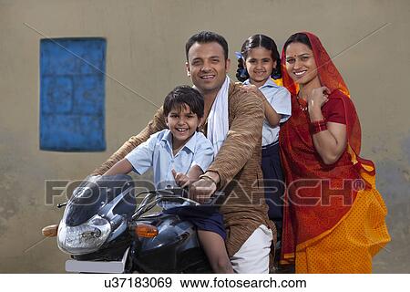 Portrait of a happy Indian family of four on bike View Large Photo Image Stock Photo - Portrait of a happy Indian family of four on bike . Fotosearch