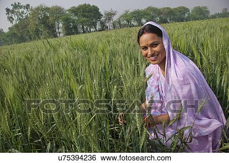 Stock Photograph - Portrait of a happy Indian female farm worker working in the field . Fotosearch