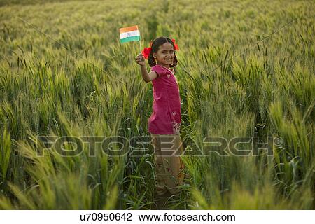 Stock Image - Portrait of a happy little girl holding an Indian flag . Fotosearch