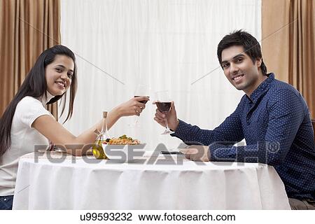 Portrait of a happy young couple on a date at restaurant View Large Photo Image Stock Image - Portrait of a happy young couple on a date at restaurant . Fotosearch