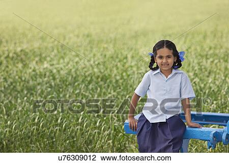 Portrait of a little rural school girl sitting in a field View Large Photo Image Stock Image - Portrait of a little rural school girl sitting in a field . Fotosearch