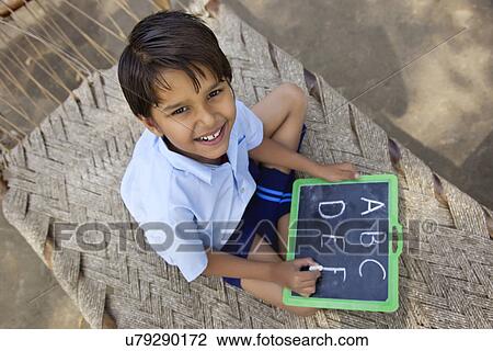 Portrait of a little school boy writing on slate View Large Photo Image Stock Image - Portrait of a little school boy writing on slate . Fotosearch