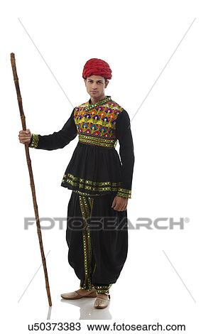 Stock Image - Portrait of a male dandiya dancer with a stick . Fotosearch