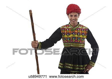 Stock Image - Portrait of a male dandiya dancer with a stick . Fotosearch