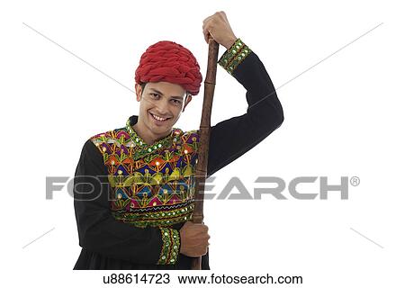 Stock Image - Portrait of a male dandiya dancer with a stick . Fotosearch