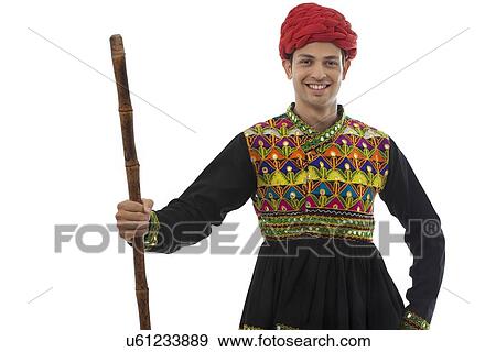 Stock Photo - Portrait of a male dandiya dancer with a stick . Fotosearch