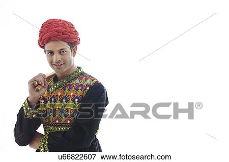 Stock Photo - Portrait of a male dandiya dancer with sticks . Fotosearch