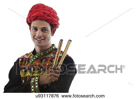 Stock Photograph - Portrait of a male dandiya dancer with sticks . Fotosearch