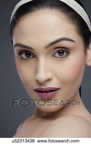 Stock Photo - Portrait of a pretty female smiling over colored background . Fotosearch