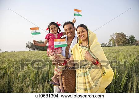 Portrait of a rural family holding an Indian flag View Large Photo Image Picture - Portrait of a rural family holding an Indian flag . Fotosearch