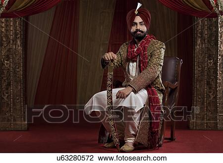 Portrait of a Sikh groom sitting with a sword View Large Photo Image Stock Image - Portrait of a Sikh groom sitting with a sword . Fotosearch