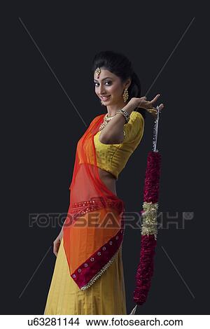 Picture - Portrait of a smiling bride holding a garland. Fotosearch