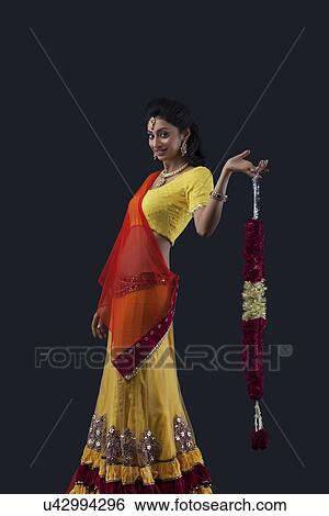 Portrait of a smiling bride holding a garland View Large Photo Image Stock Photograph - Portrait of a smiling bride holding a garland. Fotosearch