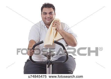 Stock Photography - Portrait of a smiling obese man exercising over white background . Fotosearch