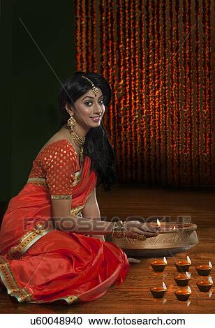 Portrait of a woman holding a diya View Large Photo Image Stock Image - Portrait of a woman holding a diya. Fotosearch