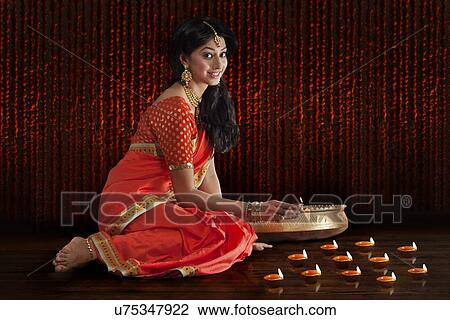 Portrait of a woman holding a diya View Large Photo Image Stock Image - Portrait of a woman holding a diya. Fotosearch