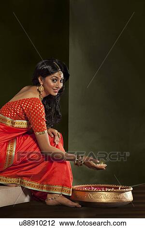 Portrait of a woman holding a diya View Large Photo Image Stock Image - Portrait of a woman holding a diya. Fotosearch