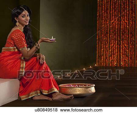 Stock Photo - Portrait of a woman holding a diya. Fotosearch