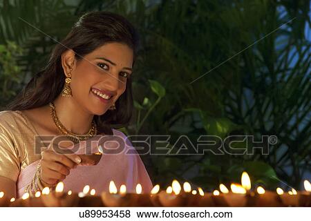 Stock Photo - Portrait of a woman holding a diya . Fotosearch