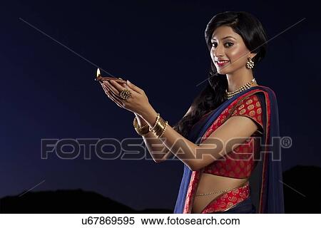 Stock Photography - Portrait of a woman holding a diya. Fotosearch