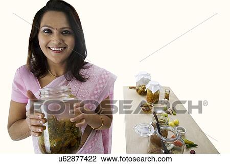 Portrait of a woman holding a jar of pickle View Large Photo Image Stock Image - Portrait of a woman holding a jar of pickle . Fotosearch