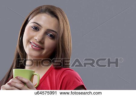 Stock Image - Portrait of a woman holding a mug . Fotosearch