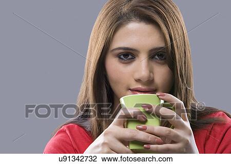Stock Image - Portrait of a woman holding a mug . Fotosearch