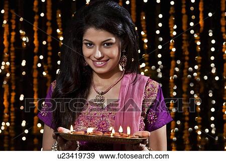 Portrait of a woman holding a tray of diyas View Large Photo Image Stock Photo - Portrait of a woman holding a tray of diyas. Fotosearch