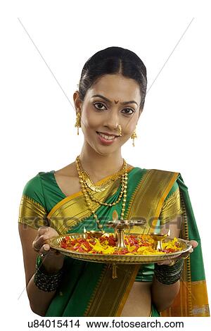 Picture - Portrait of a woman holding a tray with diyas . Fotosearch